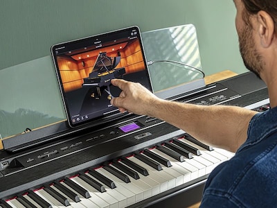 The Yamaha “Smart Pianist” app icon, together with a tablet placed on the music stand of the　P-525