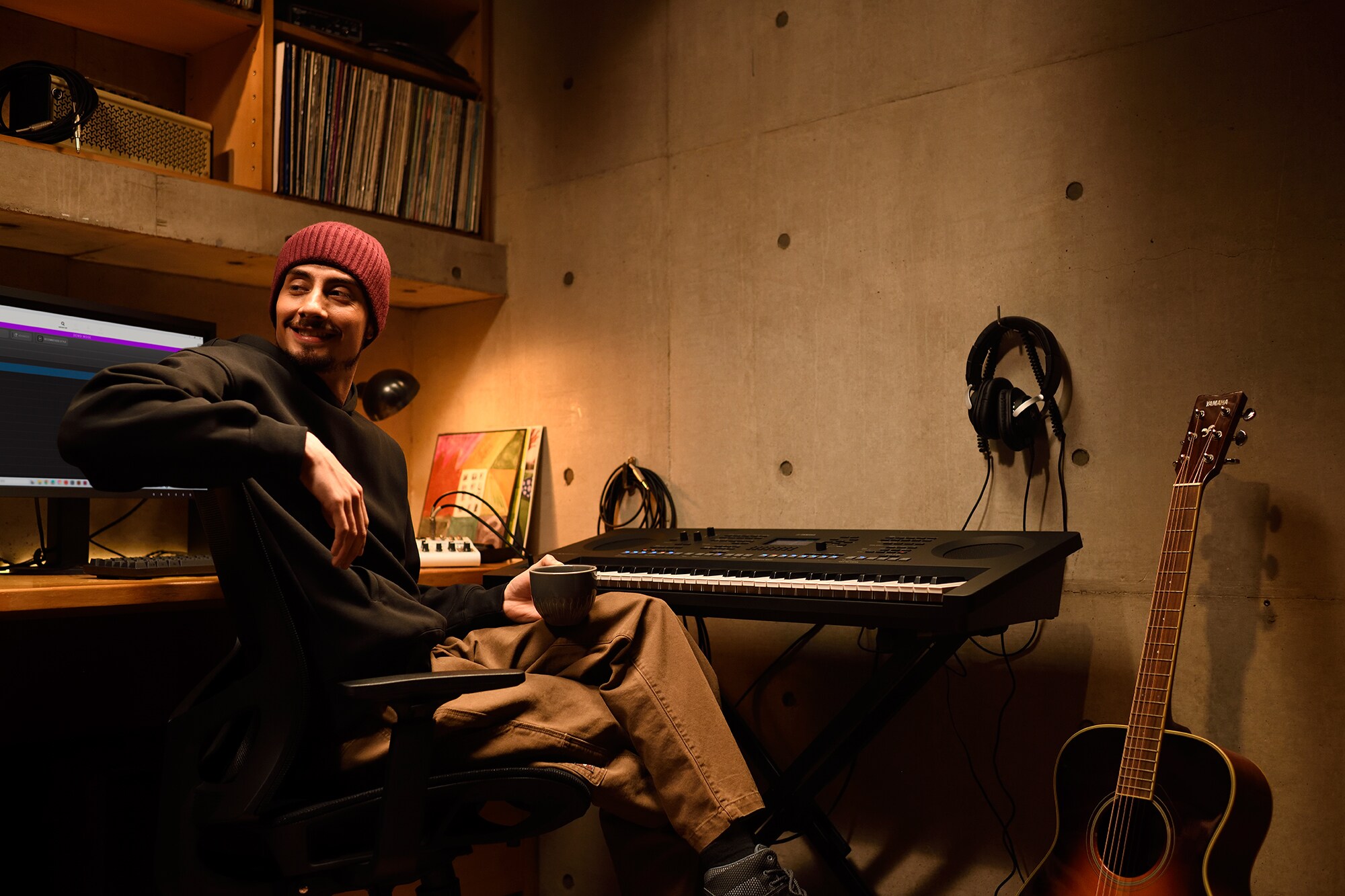 Uno spazio di lavoro musicale domestico con computer e tastiera, che mostra un tastierista al lavoro nel proprio home studio