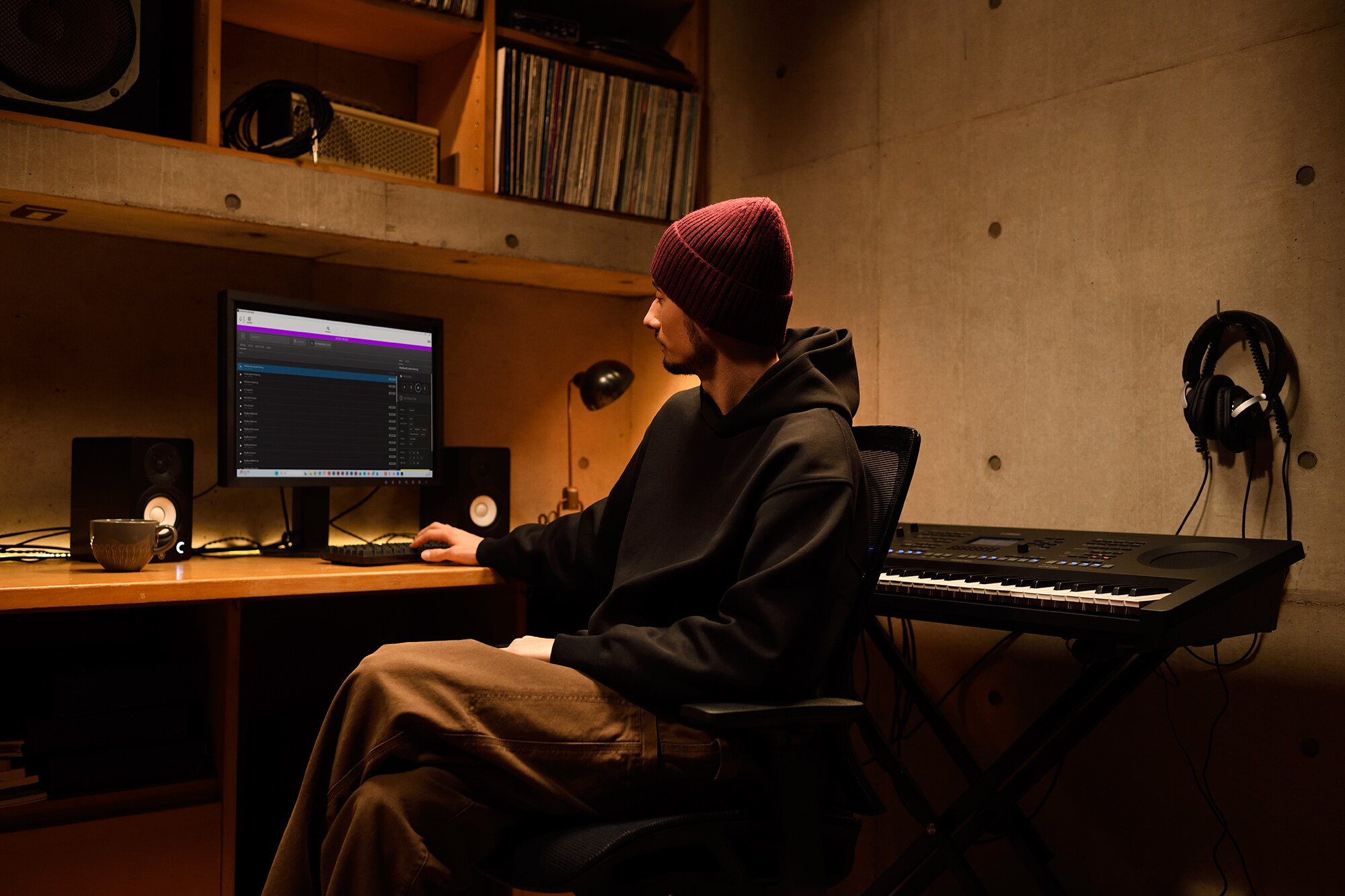 Uno spazio di lavoro musicale domestico con computer e tastiera, che mostra un tastierista al lavoro nel proprio home studio
