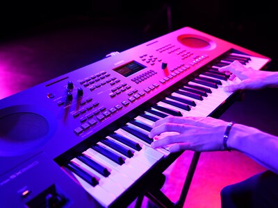 Primo piano di mani che suonano una tastiera durante una performance dal vivo.