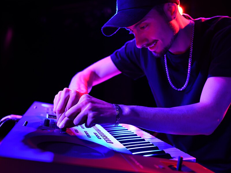 Musicista che regola le manopole Live Control su una PSR-SX620 durante una performance dal vivo.