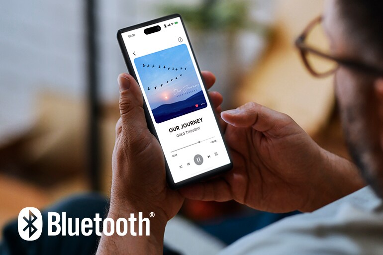 Il logo Bluetooth e un uomo che usa uno smartphone per la riproduzione musicale.