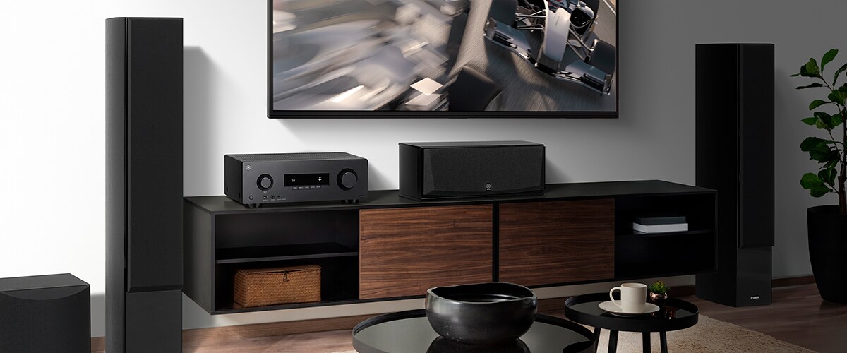 L’RX300A, un diffusore centrale, diffusori anteriori e un subwoofer in una stanza.