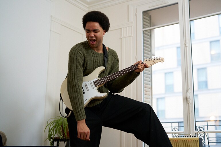 Un uomo che suona con entusiasmo una chitarra elettrica
