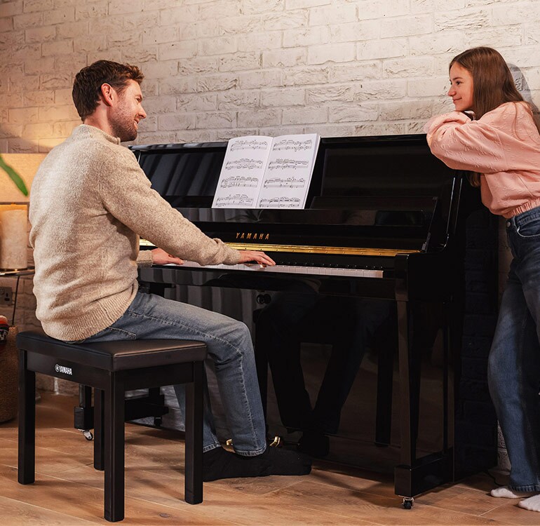 Una madre e sua figlia si divertono a suonare il pianoforte verticale della Serie B