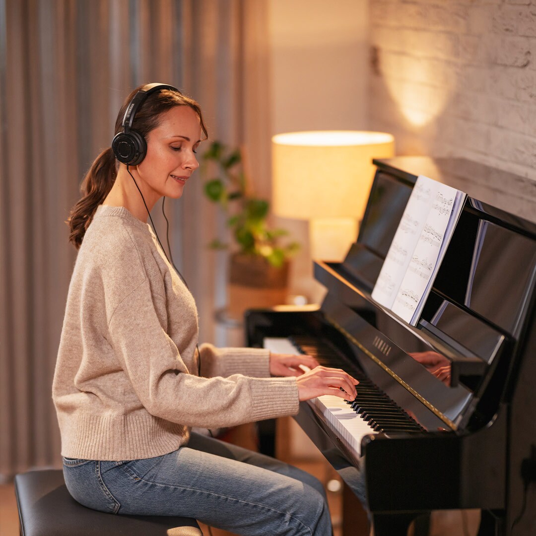 Una donna si diverte a suonare il pianoforte indossando le cuffie