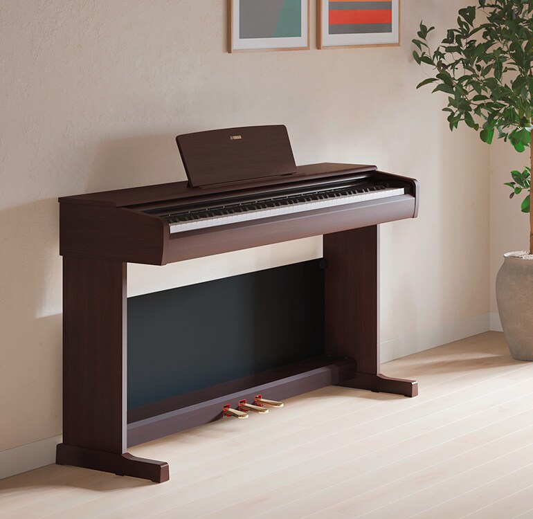 Un soggiorno con un pianoforte ARIUS, piante da appartamento e un divano, armoniosamente integrati con l’arredamento