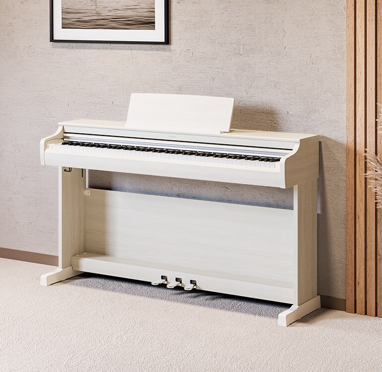 Un soggiorno con un pianoforte ARIUS in betulla bianca, piante da appartamento e un divano, armoniosamente integrati con l’arredamento